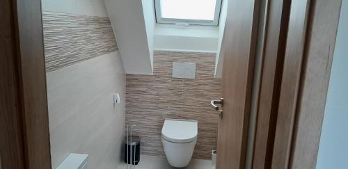 a small bathroom with a toilet and a window at Apartmán u Štěpána 