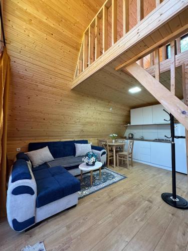 a living room with a blue couch and a table at Tlughi cottage in Itʼkhvisi