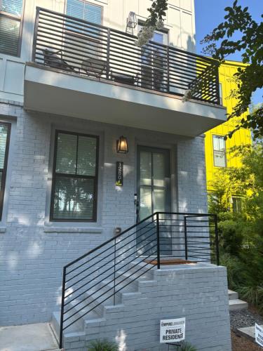 a white brick house with a balcony and stairs at 1280 Bungalow in Atlanta