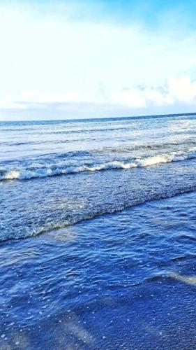 a beach with a body of water with waves at Cabaña desde 4 huéspedes 560 metros cuadrados con Naturaleza a 300 metros mar in Necoclí