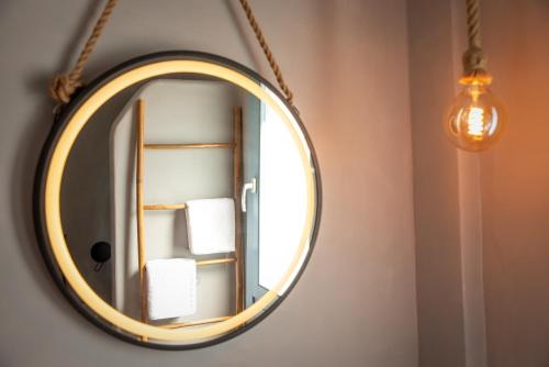 a round mirror hanging on a wall in a bathroom at Anthea Suites in Engares