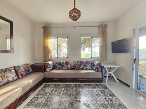 a living room with a couch and a window at Maison rurale à 800 m de plage in Restinga Smir