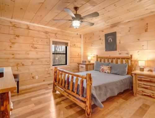 a log cabin bedroom with a bed and a ceiling fan at Mountain Heaven in Bryson City