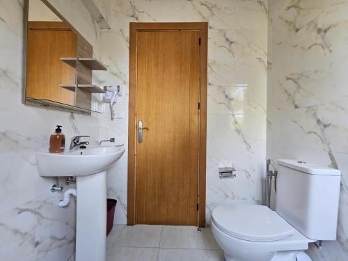 a white bathroom with a toilet and a sink at Maison rurale à 800 m de plage in Restinga Smir