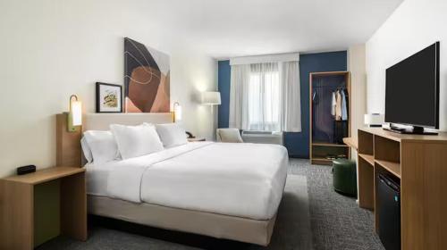 a bedroom with a large white bed and a television at Spark by Hilton Toronto Airport in Toronto