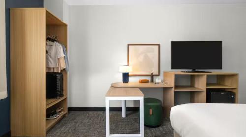 a bedroom with a bed and a desk with a television at Spark by Hilton Toronto Airport in Toronto