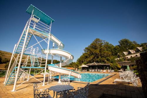 eine Wasserrutsche neben einem Pool in der Unterkunft Hotel Fazenda Bavária in São Lourenço