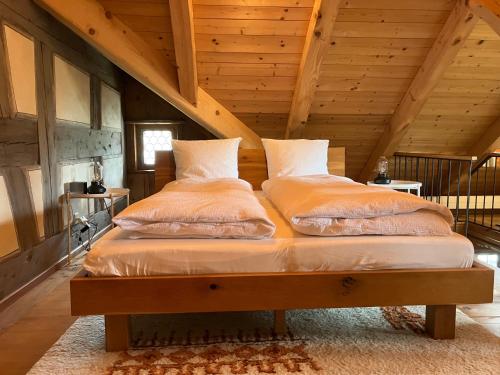 two beds in a attic room with wooden ceilings at Idyllische Wohnung im historischen Dorfhaus in Kappel