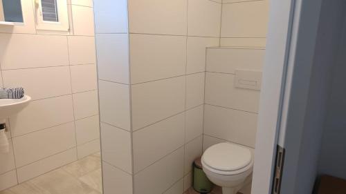 a white bathroom with a toilet and a sink at Ferienwohnungen Irmgard Mori in Sankt Kanzian