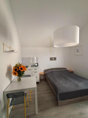 a bedroom with a bed and a table with a vase of flowers at Ludna 27 in Niechorze