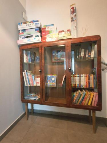 a wooden cabinet with glass doors filled with books at Ludna 27 in Niechorze