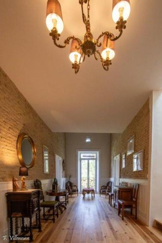 a large room with a chandelier and tables and chairs at Aux roses de Cèdres in Salvagnac