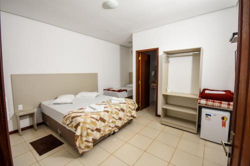 ein Schlafzimmer mit großem Bett und ein Badezimmer in der Unterkunft Hotel Fazenda Bavária in São Lourenço