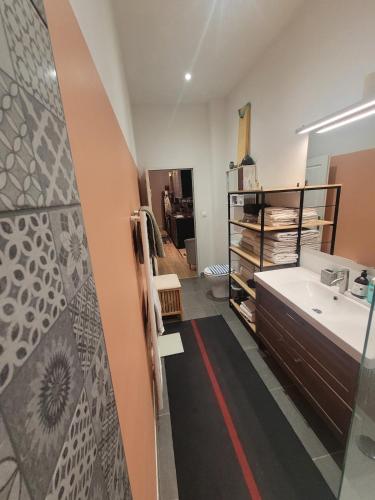 une salle de bain avec un lavabo, une baignoire et un miroir dans l'établissement L'Appartement-Studio LMS Radio, à Avignon