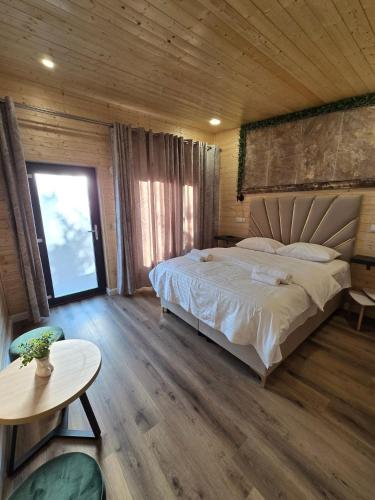 a bedroom with a large bed and a table at Bella Vista Bungalow in Turda
