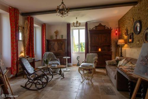a living room with a couch and a table at Aux roses de Cèdres in Salvagnac