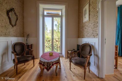 a room with two chairs and a table and a window at Aux roses de Cèdres in Salvagnac