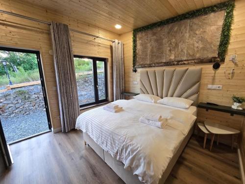 a bedroom with a large bed in a wooden cabin at Bella Vista Bungalow in Turda