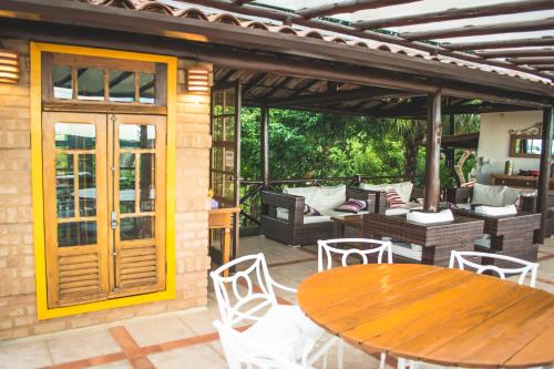 an outdoor patio with a wooden table and chairs at Pousada Janellas do Mar in Búzios