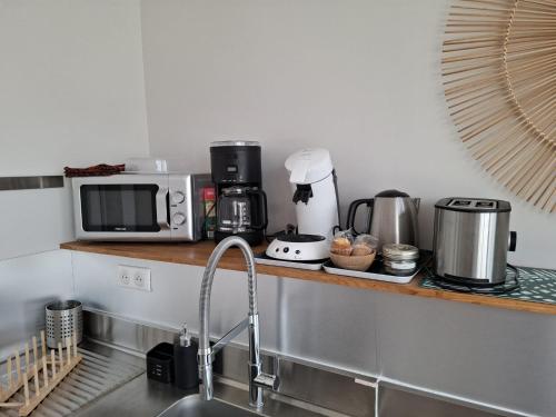 - une cuisine avec un comptoir, un four micro-ondes et un évier dans l'établissement Studio B., à La Baule