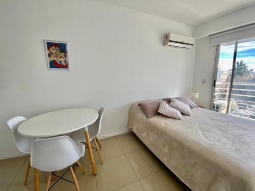 a bedroom with a bed and a table and chairs at Palermo Soho Luxury Flat with pool and Amenities in Buenos Aires