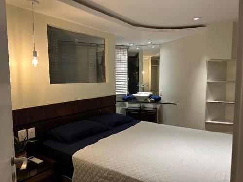 Un dormitorio con una cama y un baño con lavabo. en Condomínio do Edifício Cannes, en Río de Janeiro