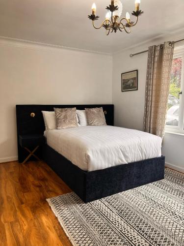 a bedroom with a large bed with a chandelier at Shared House in Inverness in Inverness