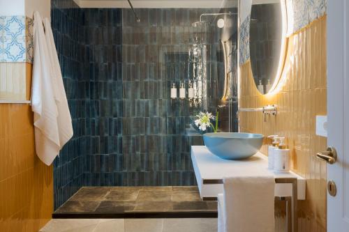 a bathroom with a sink and a glass shower at Elysium Boutique Apartment - Modica in Modica