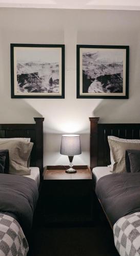 a bedroom with two beds and a lamp on a table at Soma Hotels Skardu in Skardu
