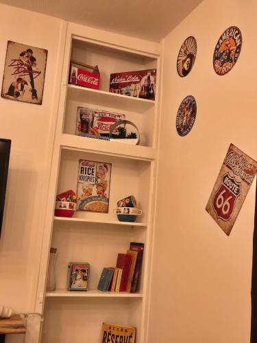 une étagère remplie de livres dans l'établissement Le petit vintage #souvenirs#, à Anet