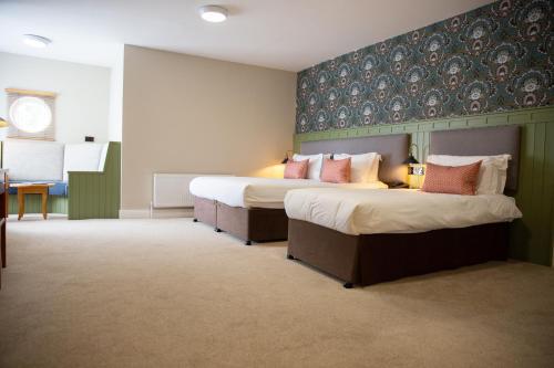 a hotel room with two beds and a desk at McGrorys in Culdaff