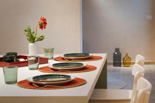 a table with plates and glasses on top of it at Elysium Boutique Apartment - Modica in Modica