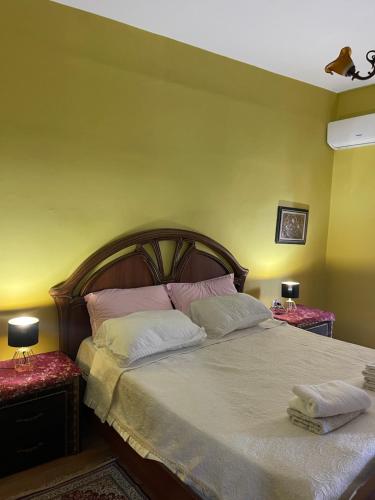 Un dormitorio con una cama grande con dos mesitas de noche. en City Center, en Durrës