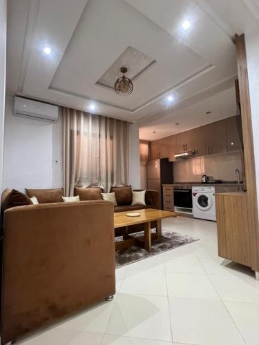 a living room with a couch and a table at Appartement cosy à 8 min de RAK à pied in Marrakech