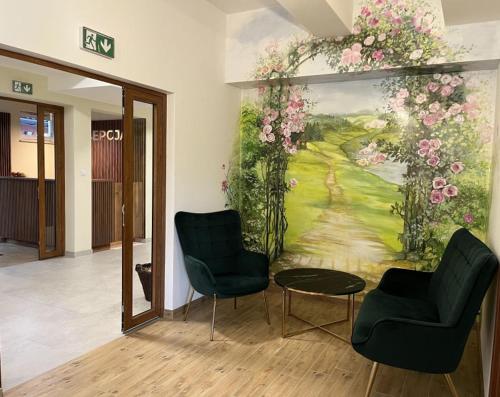 a room with two chairs and a painting on the wall at Dom Wczasowy Nad Lubaczowką in Radawa