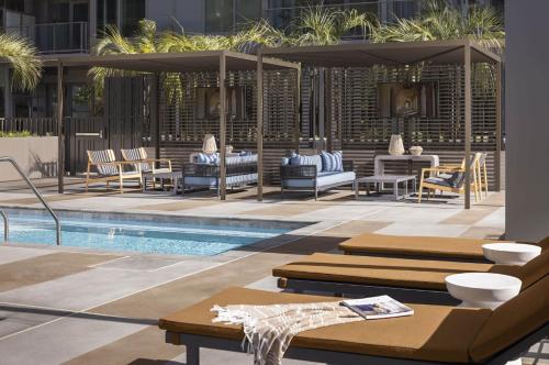 a swimming pool with lounge chairs and an umbrella at The Daisy-Highrise 2BR Marina View,Pool,Jacuzzi,Gym&Parking in San Diego