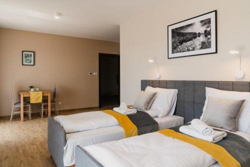 a bedroom with two beds and a table at Dom Wczasowy Nad Lubaczowką in Radawa