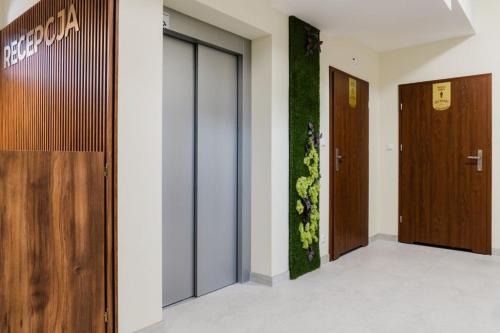 a lobby with two doors and a plant on the wall at Dom Wczasowy Nad Lubaczowką in Radawa