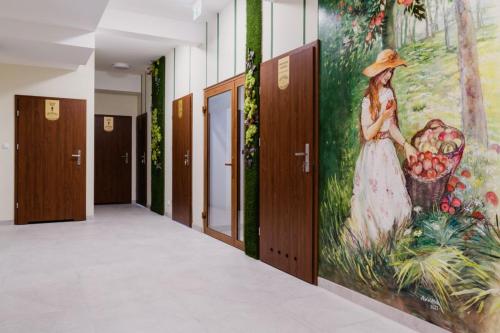 a hallway with a painting of a woman with a basket of fruit at Dom Wczasowy Nad Lubaczowką in Radawa