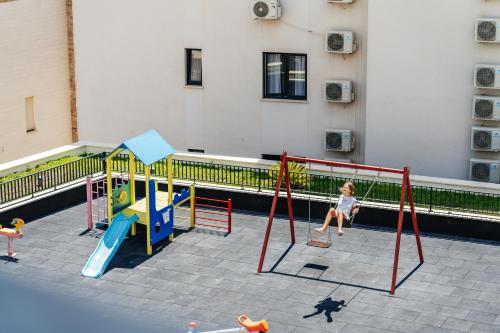 a little girl is playing on a playground at Vuelo Sobre by In Property in Becici