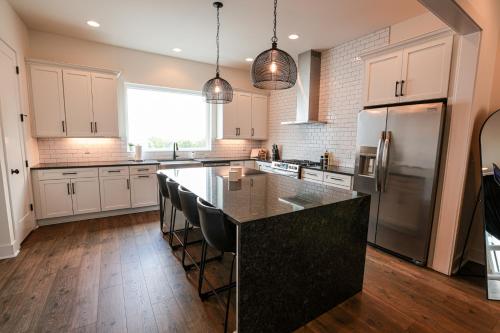 a kitchen with white cabinets and a black counter top at Nashville Riverfront Bliss in Nashville