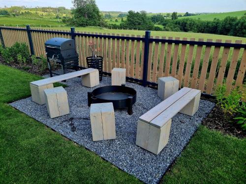 a fire pit with benches and a grill in a yard at Chalupa U Jasanu in Vílanec