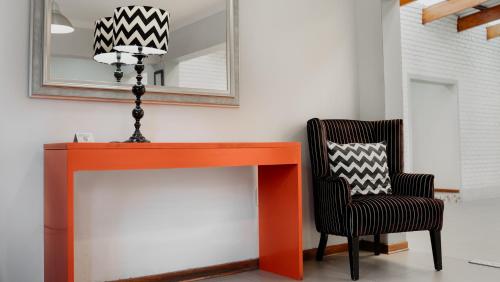 a desk and a chair next to a mirror at Yalla Yalla Boutique Hotel in Witbank