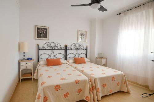 1 dormitorio con 1 cama con almohadas de color naranja en Central Park-Coastal Refuge by the Beach, en Estepona