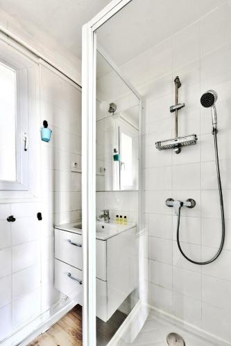 une salle de bain blanche avec une douche et un lavabo dans l'établissement Appart le Jules Guesde 3ch Traversant, Métro D Parilly, place de parking, à Vénissieux