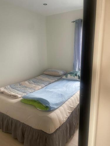a small bed in a room with a window at Senator appartment with 3 bedrooms near Oslo Airport in Råholt
