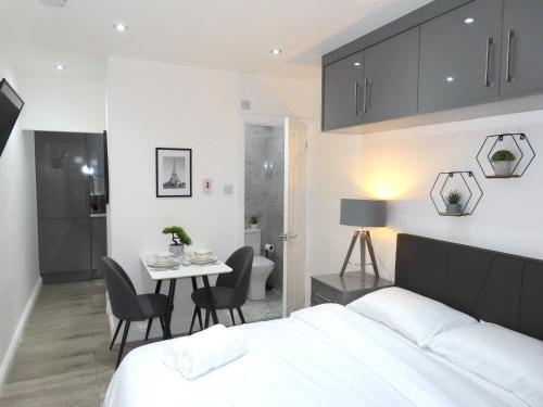 a bedroom with a bed and a table and chairs at 6 Mins to NEC & BHX Apartment with FREE Parking in Sheldon
