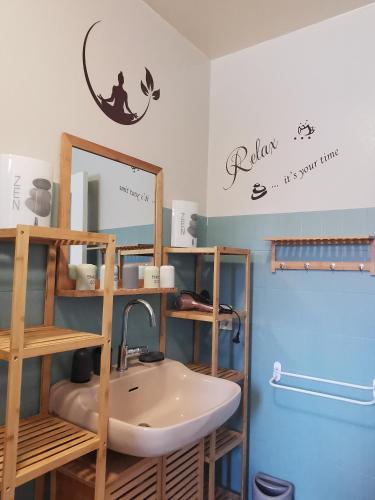 une salle de bain avec un lavabo et un miroir dans l'établissement Le Temps des Cerises, à Saint-Georges-en-Couzan