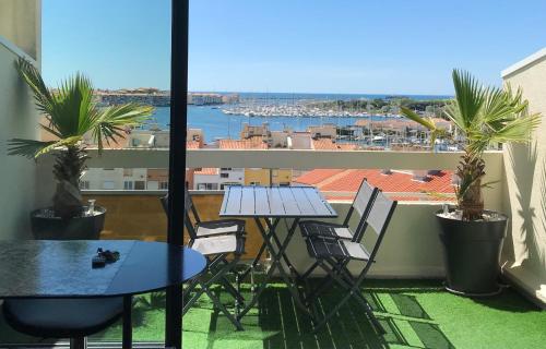 une table et des chaises sur un balcon avec vue dans l'établissement Studio mezzanine Cap d’Agde vue sur port et mer, au Cap d'Agde