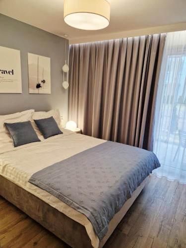 a bedroom with a large bed and a large window at Morskie Sny in Grzybowo
